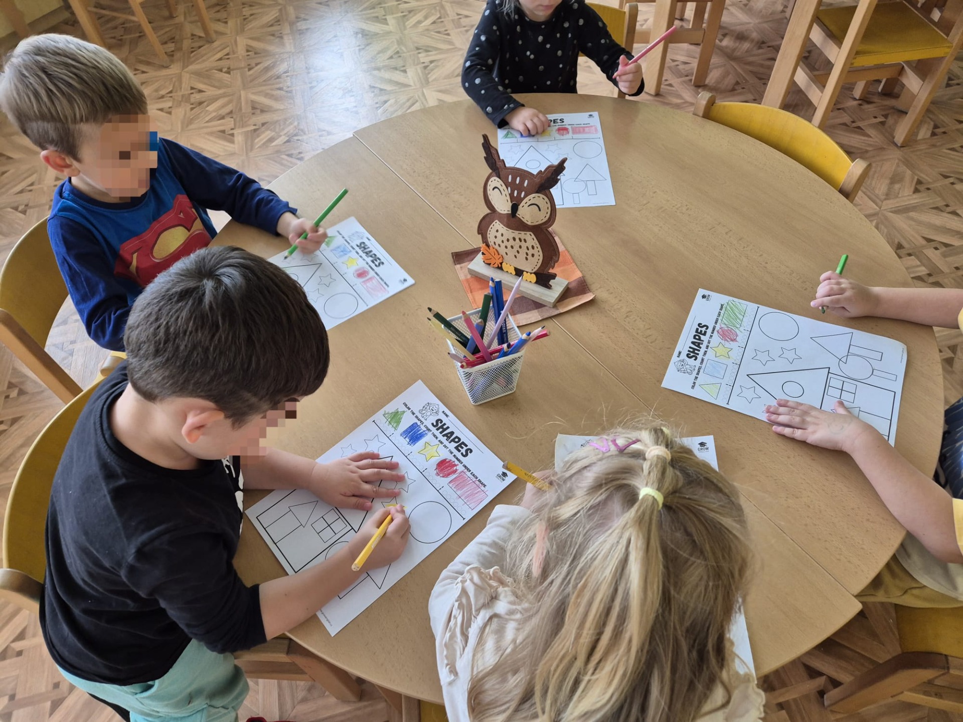 Skupina dětí ve školce pracuje na pracovních listech do angličtiny – PDF pro MŠ
