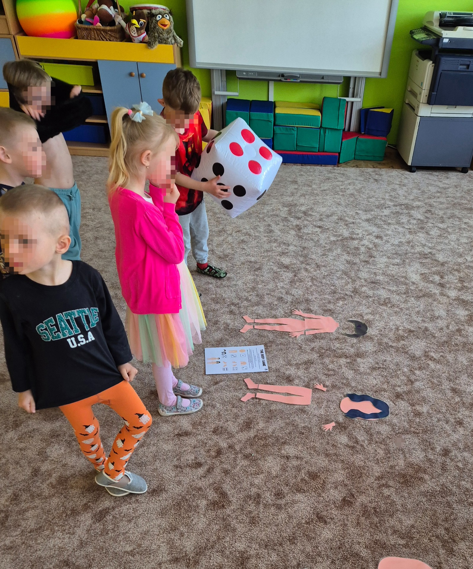 Výuka angličtiny pro děti pomocí hry Body Parts Dice Game. Děti hází kostkou, skládají části lidského těla a procvičují názvy částí těla v angličtině. Pohybová aktivita vhodná pro mateřské školy, předškoláky, 1. stupeň základní školy i lektory angličtiny.